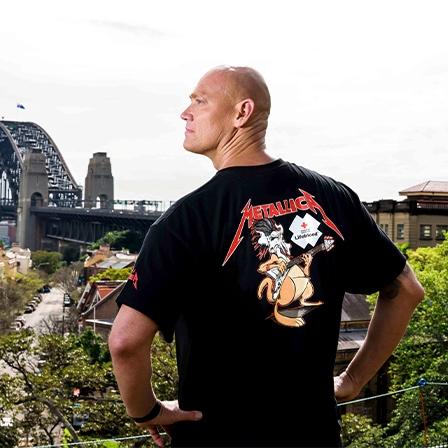 Michael Klim wearing the Lifeblood and Metallica collab t-shirt looking towards the Sydney harbour bridge