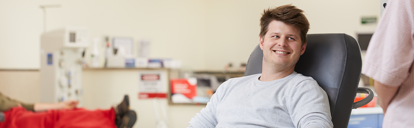 Male donor sitting in a chair while giving blood