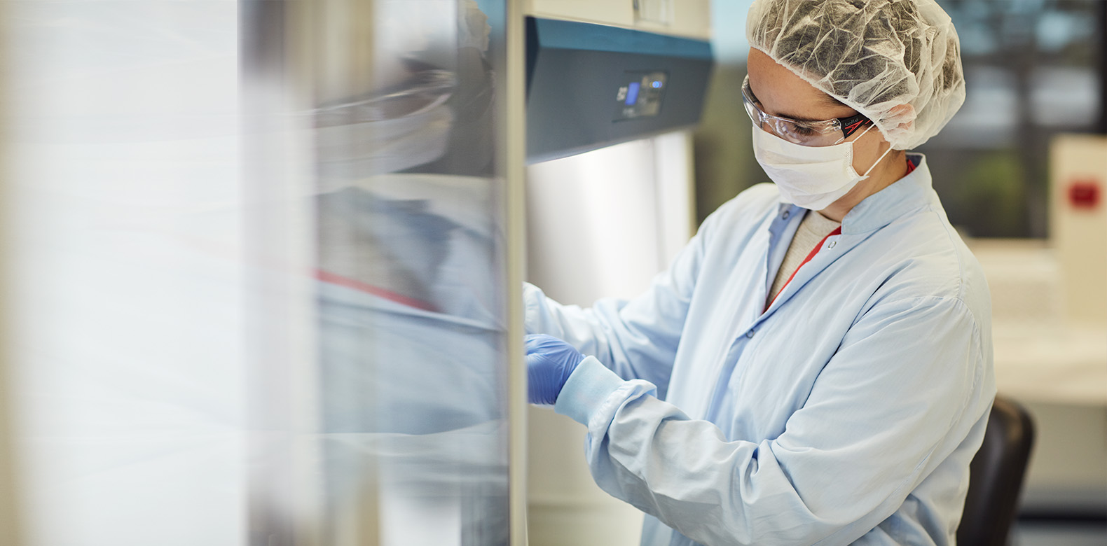 a lab worker opening a refrigerator