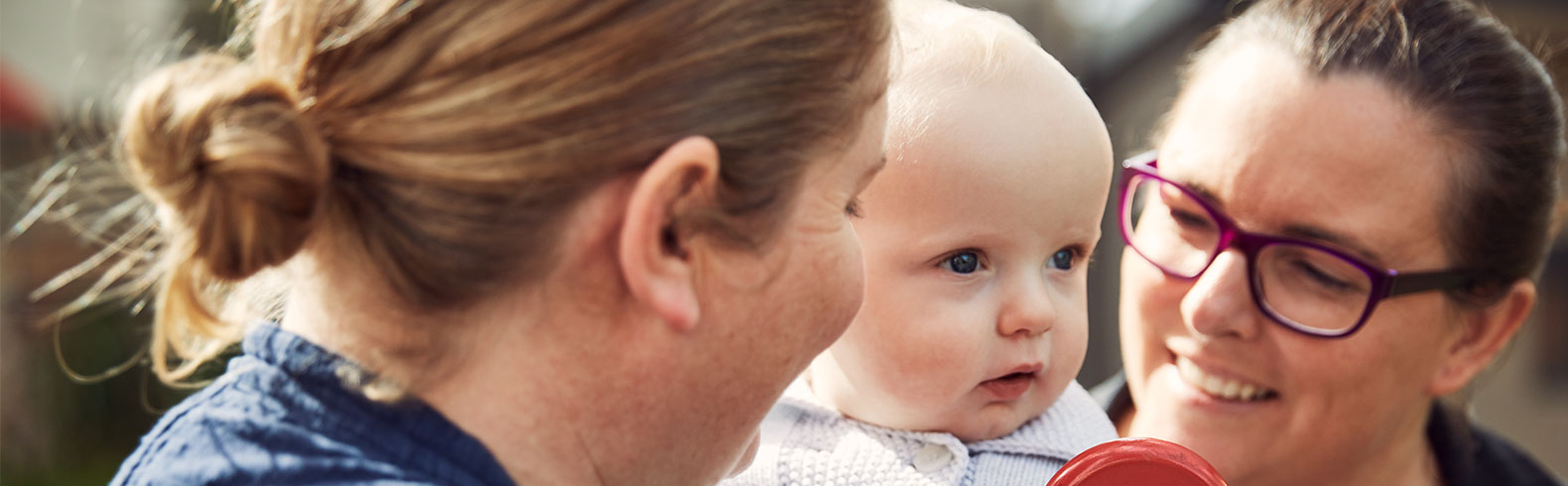 close up of parents holding their baby and smiling