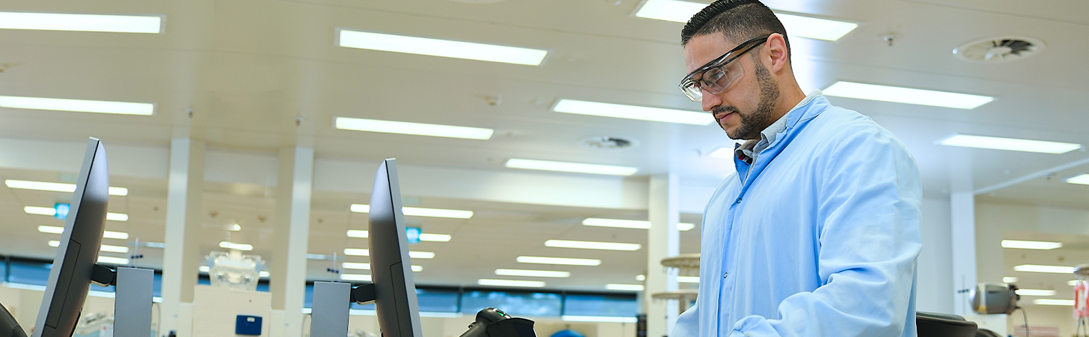 a scientist is wearing a blue gown and gloves and is scanning a donation