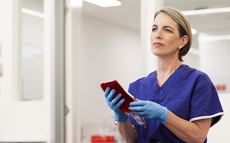 photo of nurse emma wearing a blue top and gloves holding a blood bag