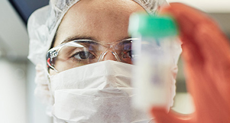 a scientist holding up a vial