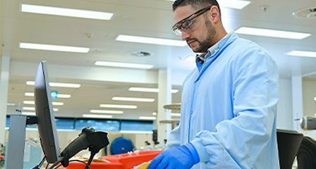 a scientist at a computer scanning a bag of plasma