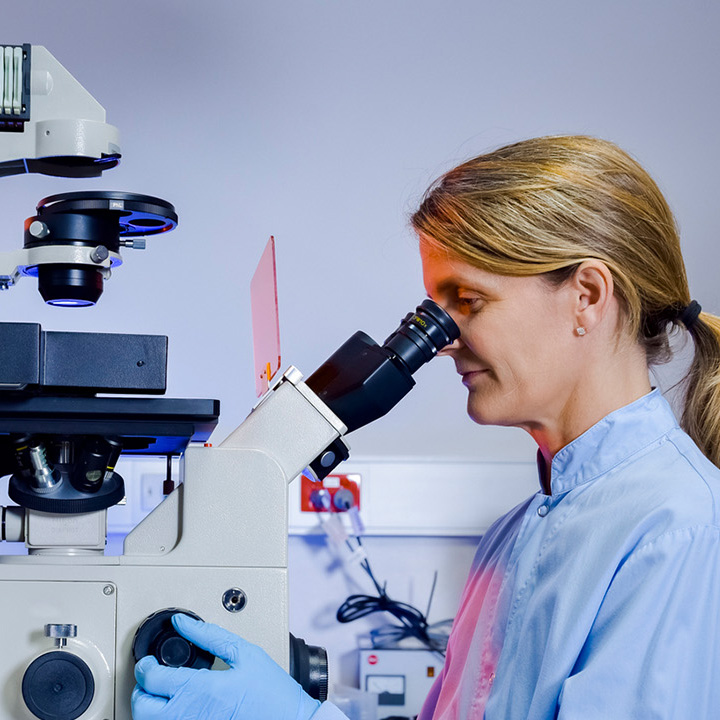 scientist looking in microscope