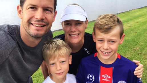 a family smiling at the camera with trees in the background