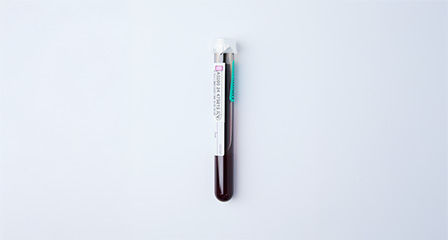 a sample container with red product inside it and a label on the side