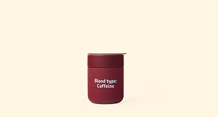a reusable travel mug with blood type caffeine written on it