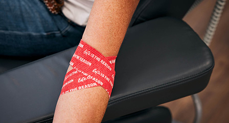 photograph of an arm wrapped in red life is the reason branded bandage