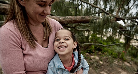 photo of a woman and child sitting outdoors and smiling