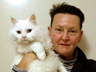 donor barbara is looking into the camera and holding up a white cat