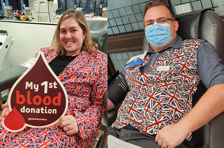 woman wearing a UK themed blazer holding up a sign that says 'my 1st blood donation' sitting in the donor chair and man wearing a UK themed vest donating blood