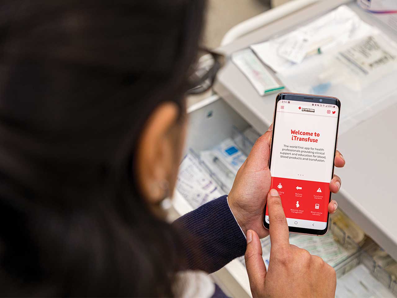 a doctor is using the itransfuse app on a smartphone