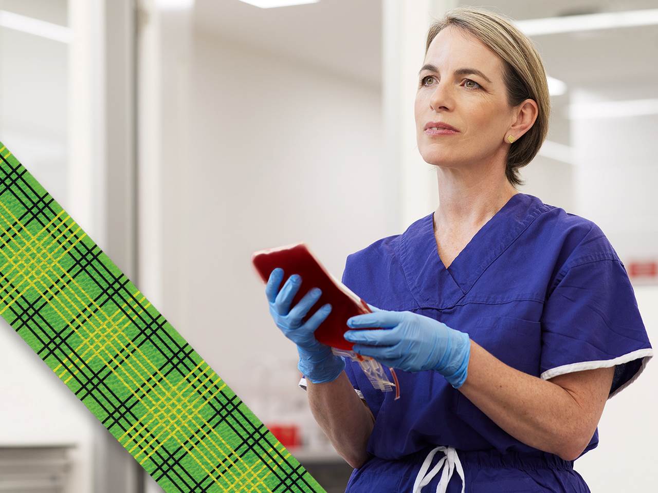 photograph of a nurse dressed in blue scrubs wearing blue gloves holding a blood bag, to the left is the bandage design by Lisa Gorman