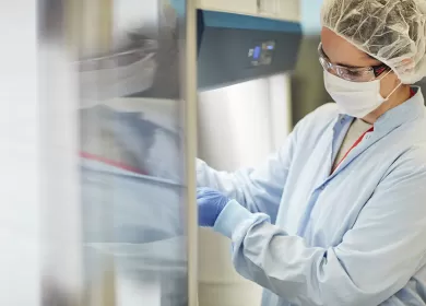 a lab worker opening a refrigerator