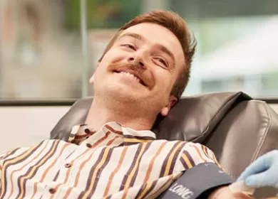 Man is smiling as he gives a blood donation