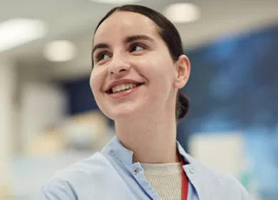 close up of a scientist looking over her right shoulder and smiling