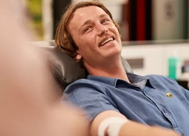 photo of a donor sitting back in a chair during a donation looking up and smiling