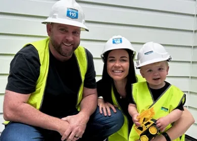 a family of three all wearing high vis and hardhats