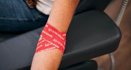 photograph of an arm wrapped in red life is the reason branded bandage