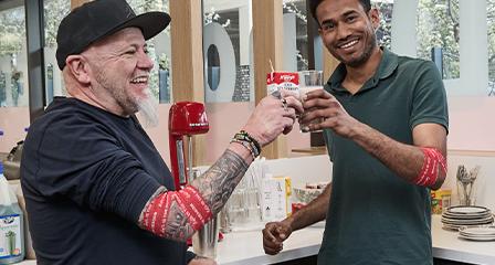 image of two male donors enjoying a post-donation snack and showing off their lifeblood branded bandages