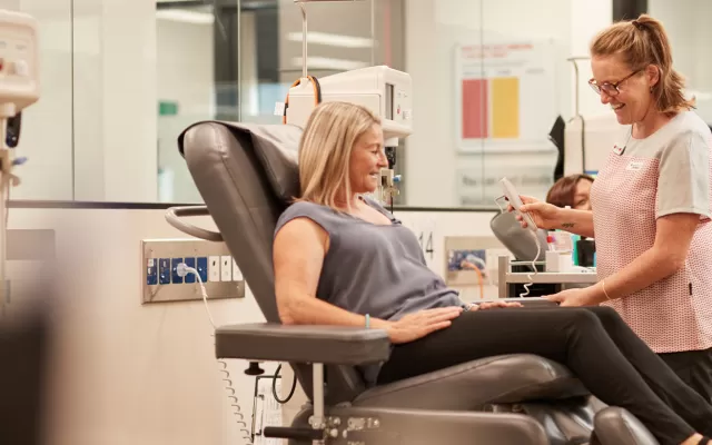 A female donor and a nurse attending to her as she donates blood