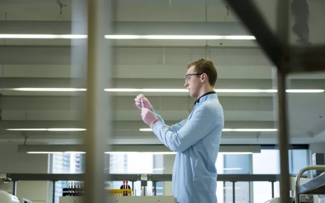 Lifeblood staff in the lab, holding a test tube