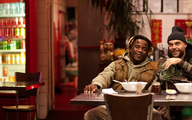 three men are sitting at a table in a vietnamese restaurant