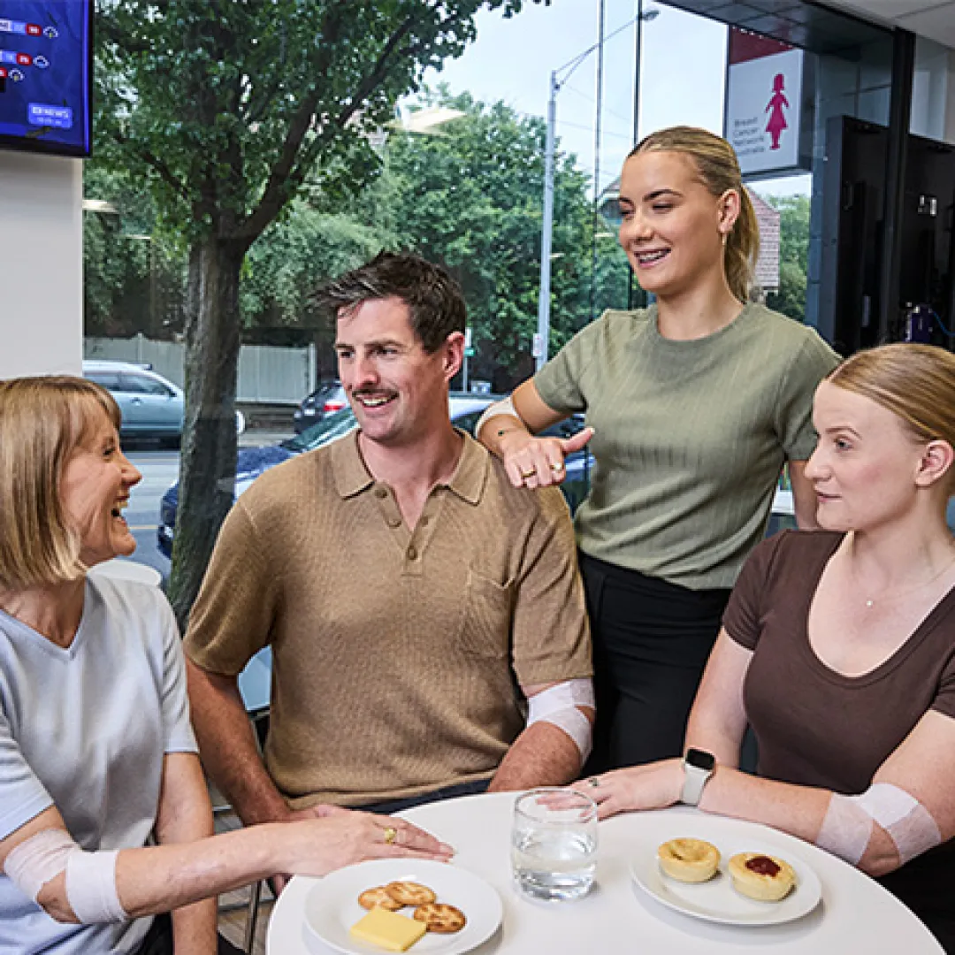 four people around a table eating snacks and drinking water