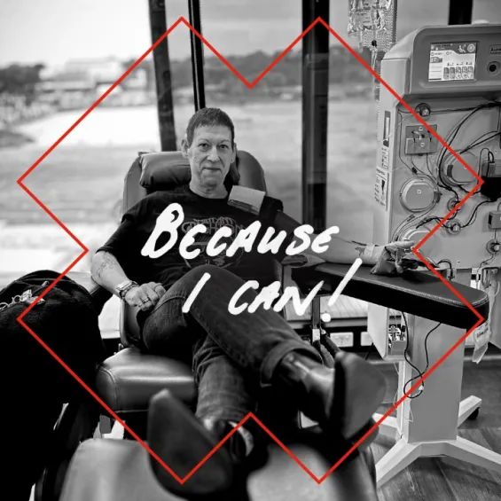 a person seated in a chair giving a donation with text because I can written over the image