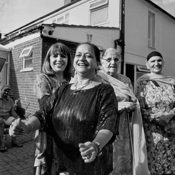 a group of people gathered outside a house laughing and smiling