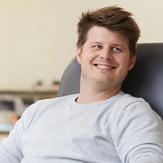 a man smiling sitting in blood donation chair