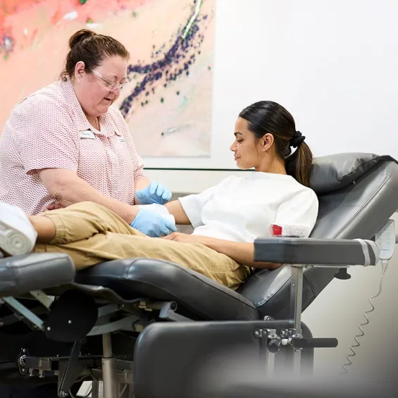 a nurse is assisting a person in a chair about to donate