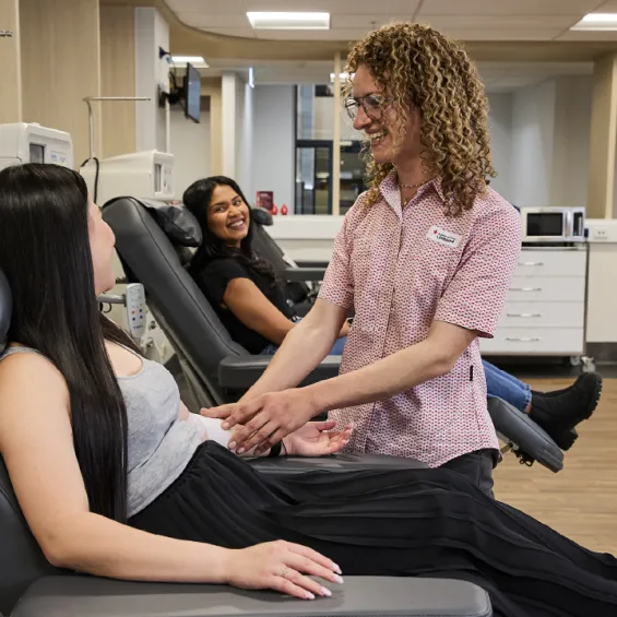 two people seated in donor chairs with a nurse talking to them
