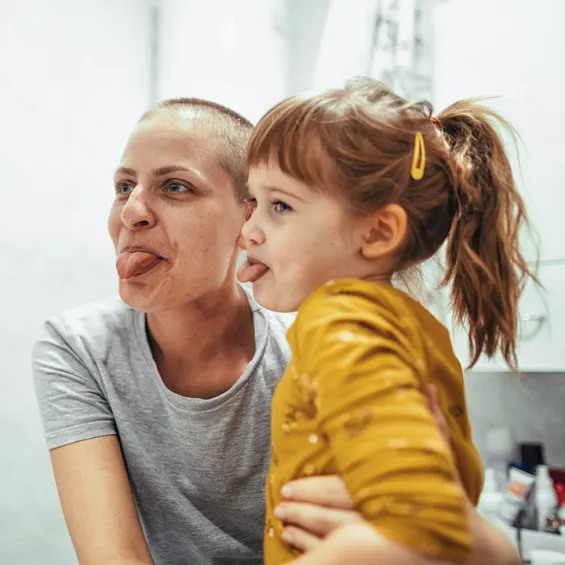 a mother and daughter laughing and poking their tongues out
