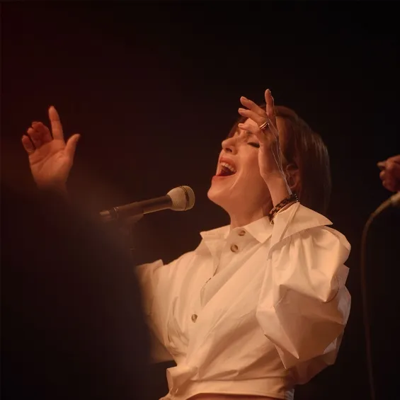 tina arena on stage singing into a microphone