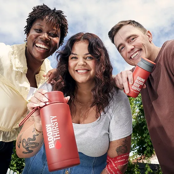 three people holding the gifts products and smiling at the camera