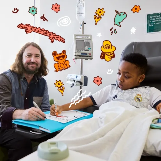David Booth and a child drawing on paper