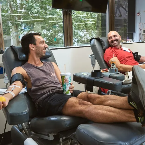two men seated in a donor centre during a donation
