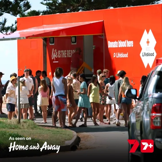 photo of a lifeblood mobile donor van with a group of people outside, the text reads as seen on Home And Away