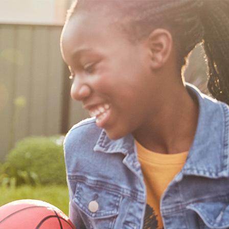 two sisters sitting in their garden playing with a ball