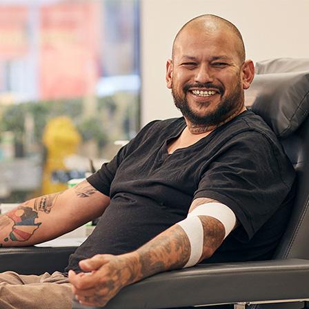a man seated in a donor chair and smiling