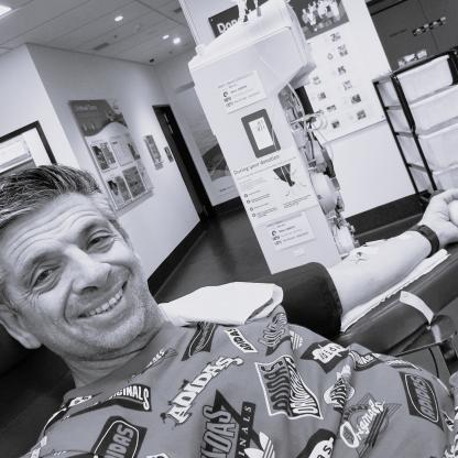 A man smiling while donating