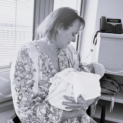 A woman holding a young baby in a hospital