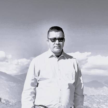 A man in sunglasses standing in front of mountains