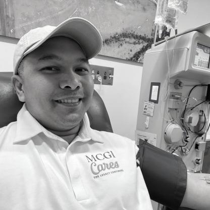 man taking a selfie whilst donating, smiling to camera