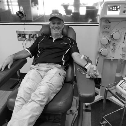 man sitting in a donor chair smiling to camera