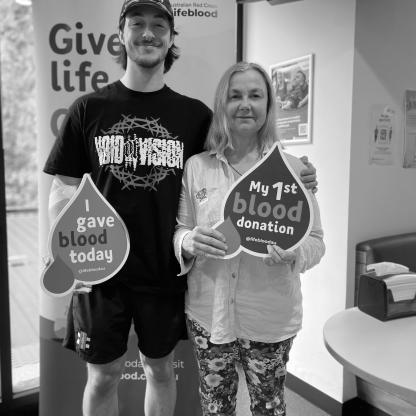 mother and son in a donor centre holding 'my 1st donation' sign