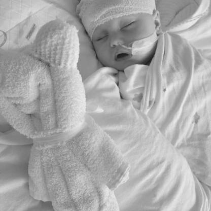 very small baby in a hospital incubator with tubes