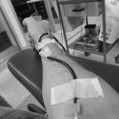 man donating showing the needle in his arm